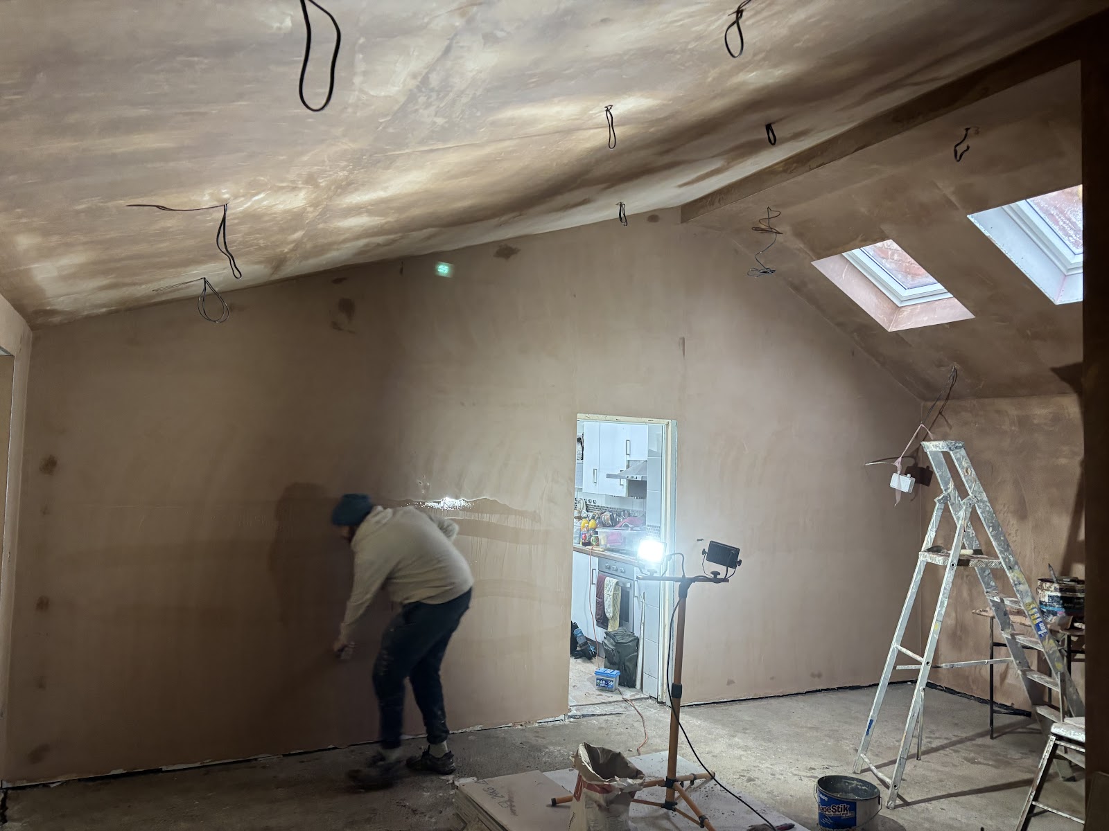 Plasterer skimming a wall to a smooth finish on a Stockport job